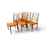 Ensemble de six chaises de salle à manger vintage Niels Otto Møller 1960 en palissandre avec assises en cuir noir, vues de trois-quarts.
