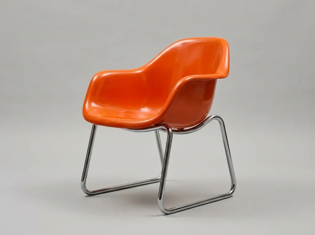 Chaise vintage des années 70 en plastique moulé orange et piétement en métal tubulaire chromé.