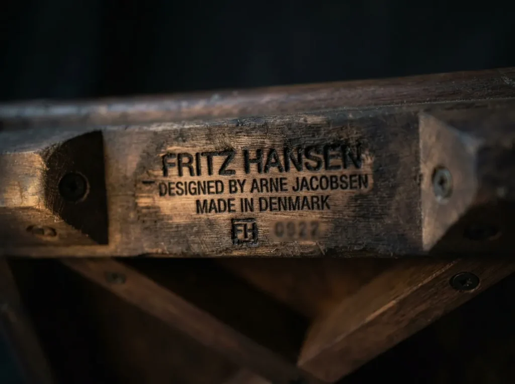 Gros plan sur une estampille de fabricant gravée sous le bois d'une chaise vintage authentique.